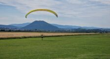 V pozadí šariššký hrad, pred ním nacvičuje s krídlom účastník motorového paraglajdingu.