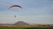 farebný paraglider počas letu nad krajinou